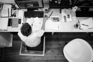 Overhead view of a cluttered work desk showing chronic stress and burnout symptoms beyond simple tiredness